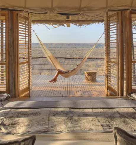 a luxury tented suite with a hammock overlooking the bush