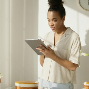 A woman updates her ecommerce website on her iPad tablet.
