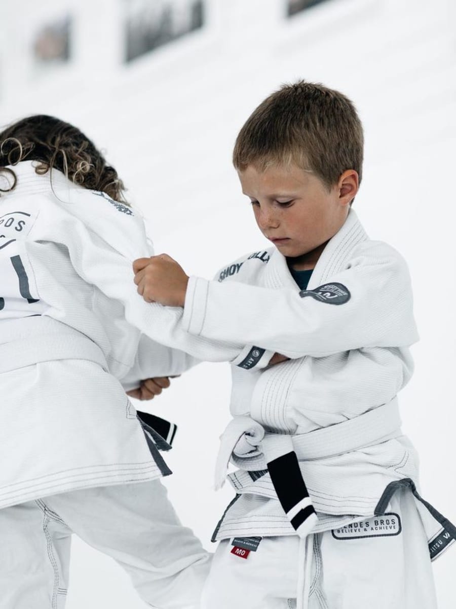 Enfant de 4 ans apprenant une roulade sur le tatami lors d'un cours Baby au Camp des Loups Villejuif