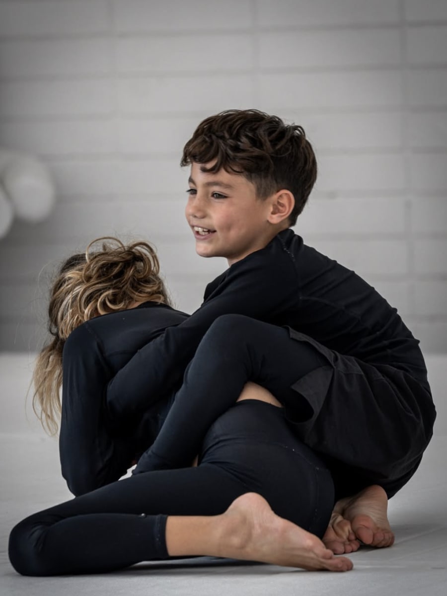 Enfants en kimono blanc concentrés lors d'un cours Kids BJJ au Camp des Loups