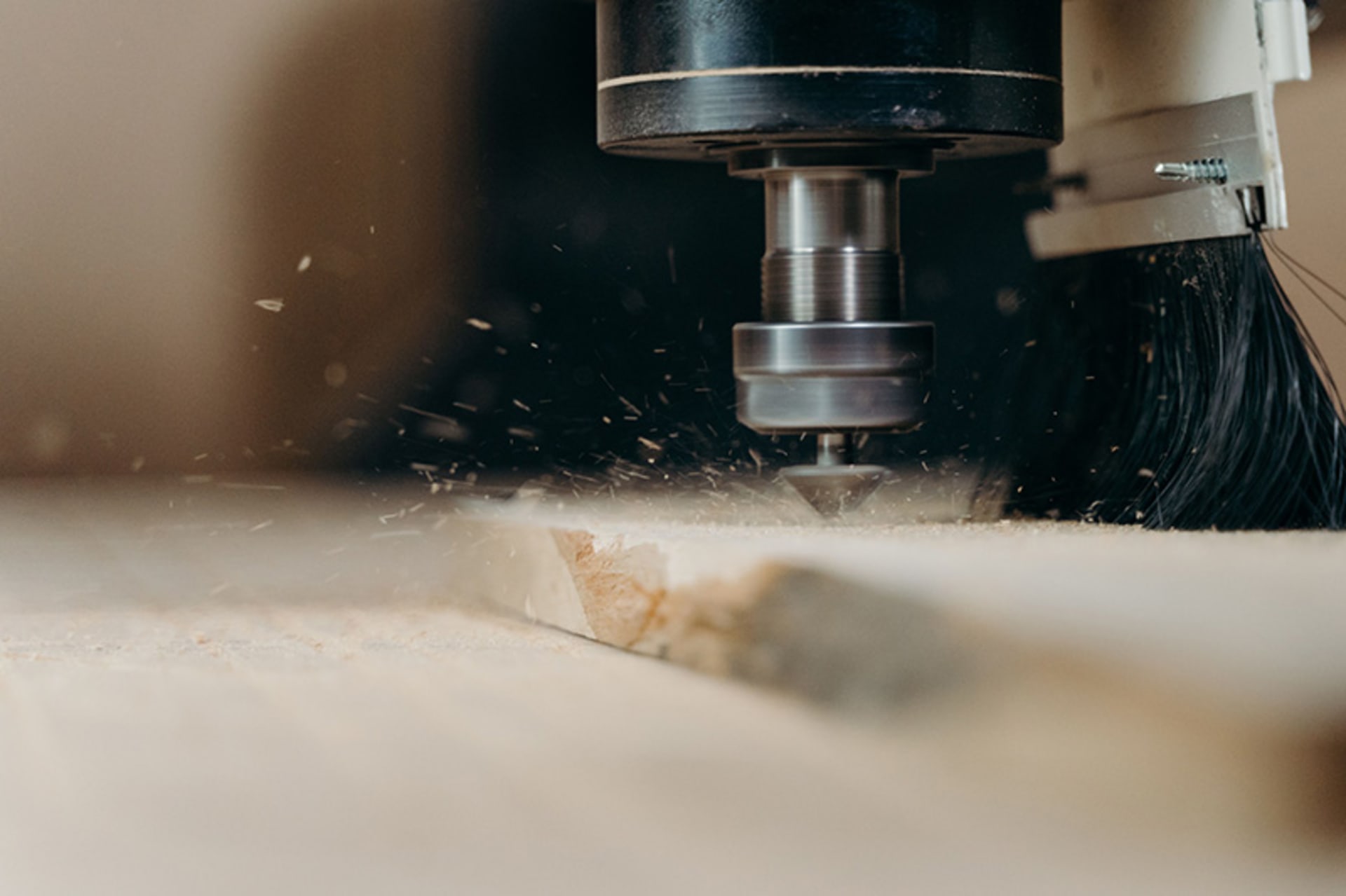 CNC-Fräsen von Holzwerkstücken CNC-Frässpindel bei der Bearbeitung eines Holzwerkstücks mit sichtbaren Holzspänen und einer Absaugbürste