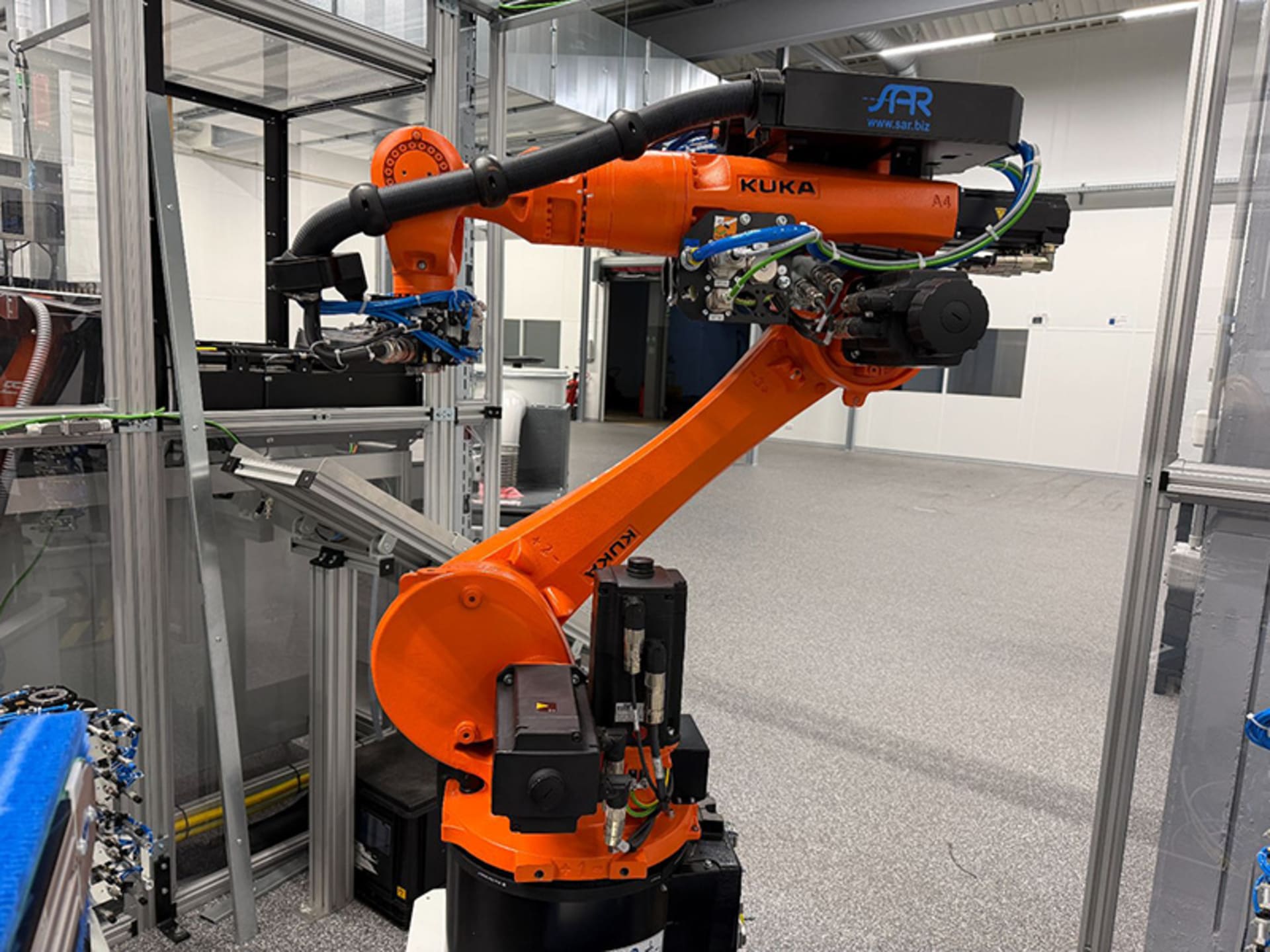 Used KUKA KR 22 R1610-2 /SEL Handling Robot Used orange KUKA KR 22 R1610-2 /SEL handling robot inside an enclosed production cell