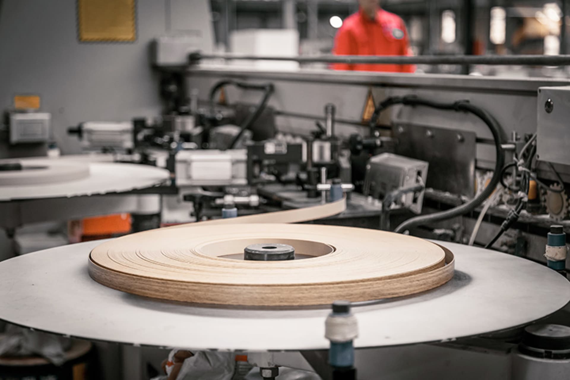 Roll of edge banding on the feed table of an industrial edgebander