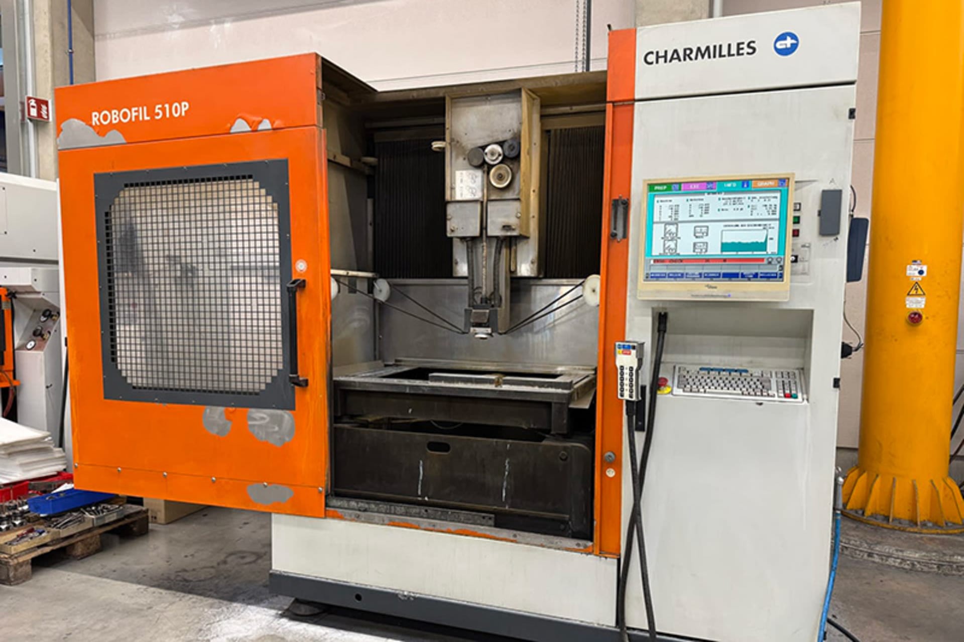 CHARMILLES ROBOFIL 510P - Arbeitsraum und Steuerung CHARMILLES ROBOFIL 510P mit geöffneter orangefarbener Schutztür, sichtbarer Drahtführung und Bedienbildschirm rechts