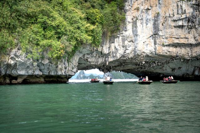 Thuyền nhỏ dưới vòm đá vịnh Hạ Long