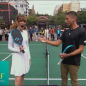Mary Berg gets a pickleball lesson from professional athlete Zane Navrat...