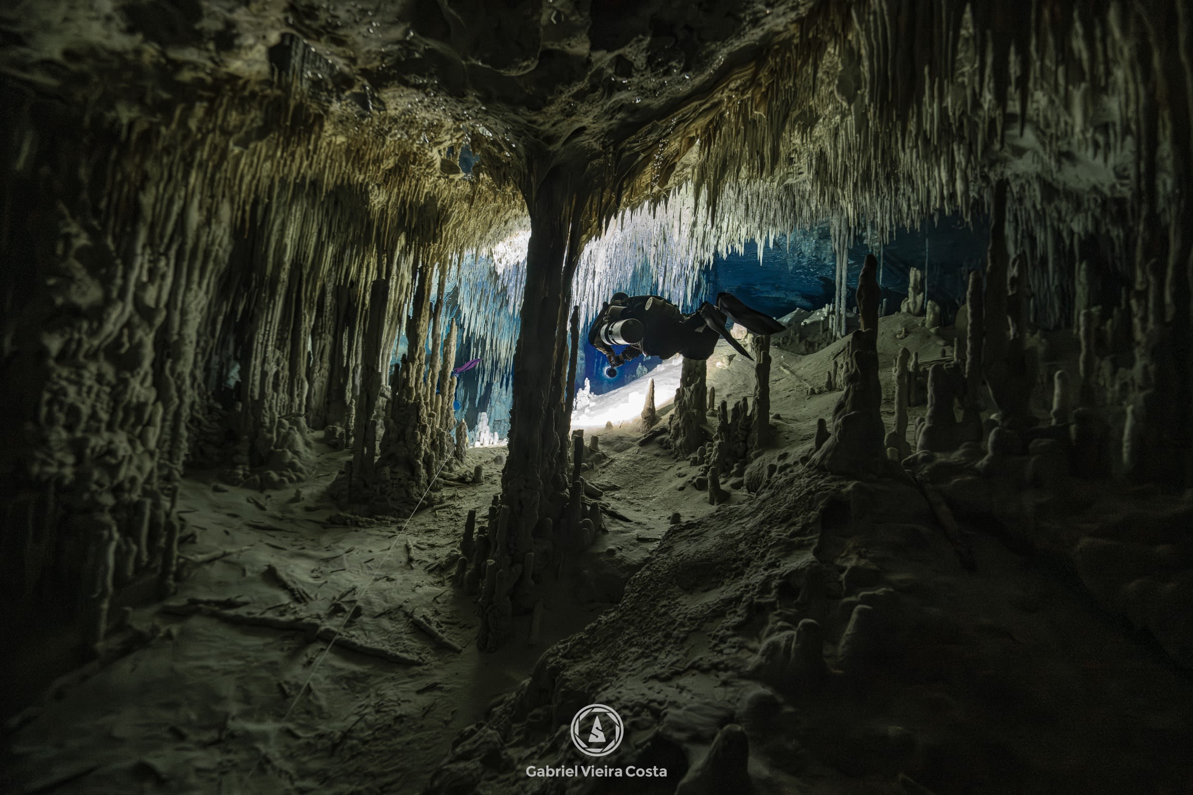 Mergulhador entre estalactites em cenote