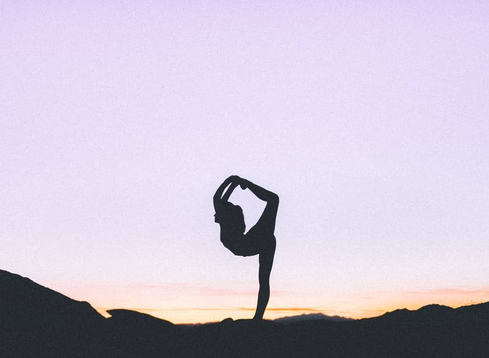 A woman stretches along a horizon