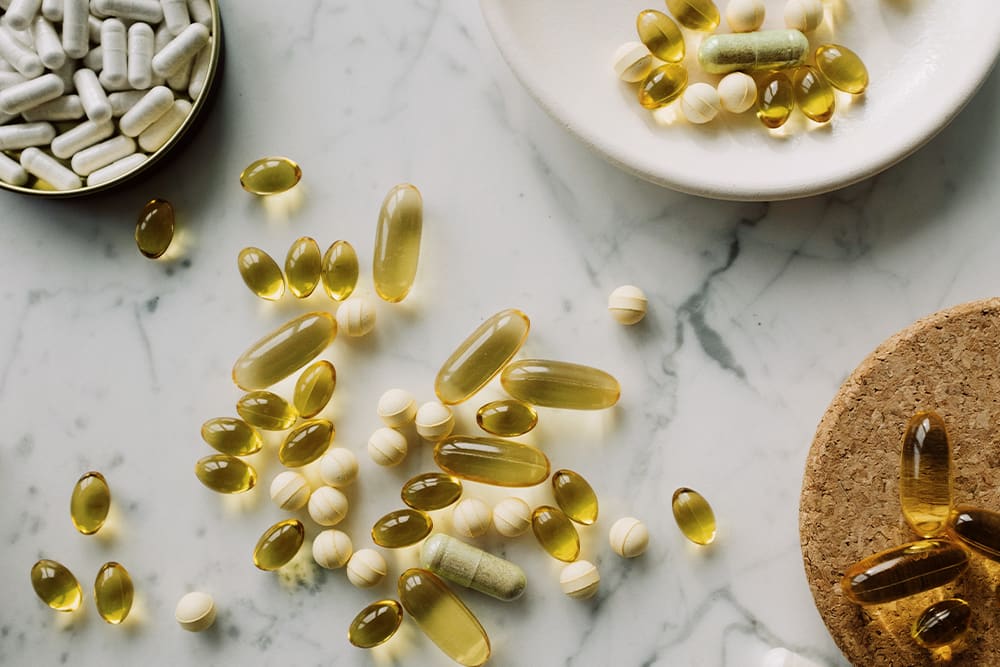 A variety of different pills mixed with kratom capsules.