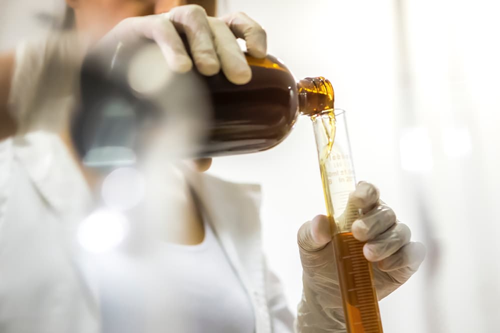 Scientist pours CBD oil to test for antimicrobial effects