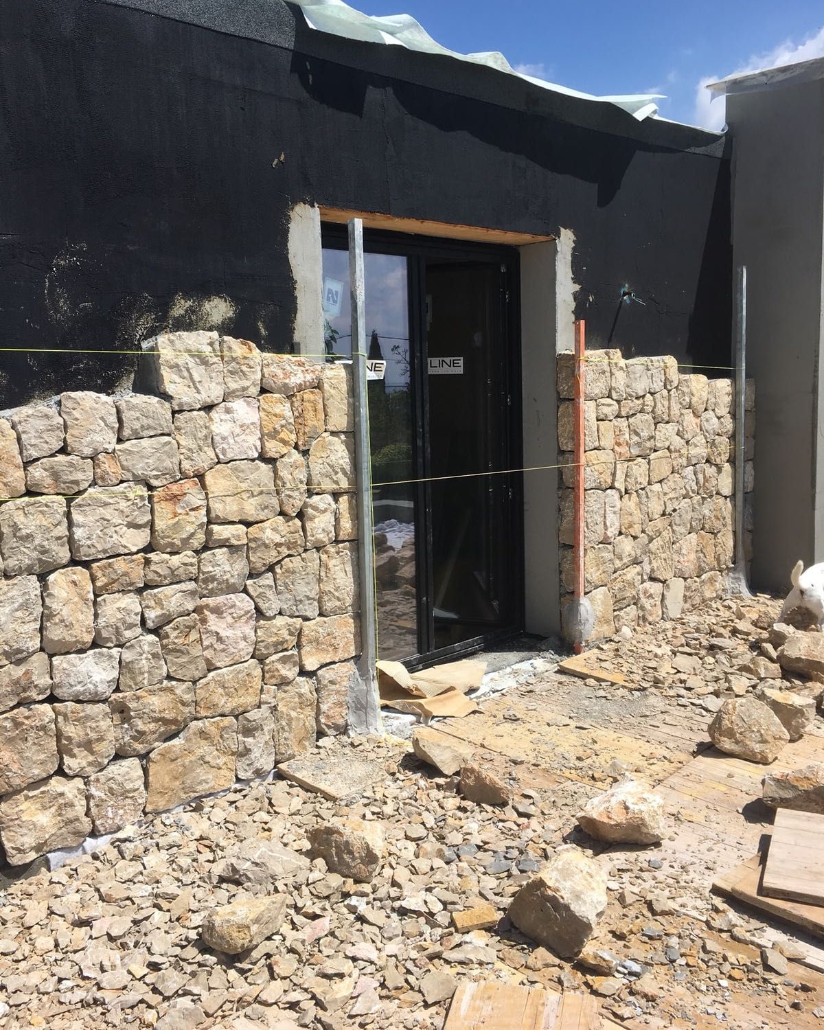 Von Hand behauene Steine werden in die Mauer gesetzt