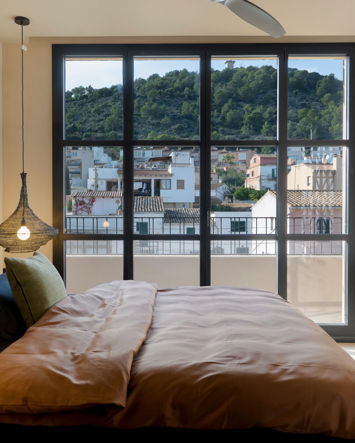 Das Hauptschlafzimmer mit seinem hohen Fenster über den Dächern von Gènova, Fuster 8