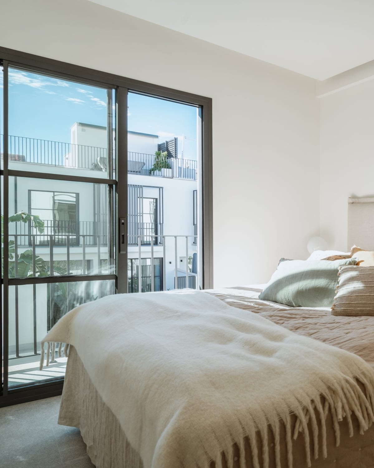 Ein Schlafzimmer, das Bett vor einer verglasten Tür, Reihenhaus in Portixol