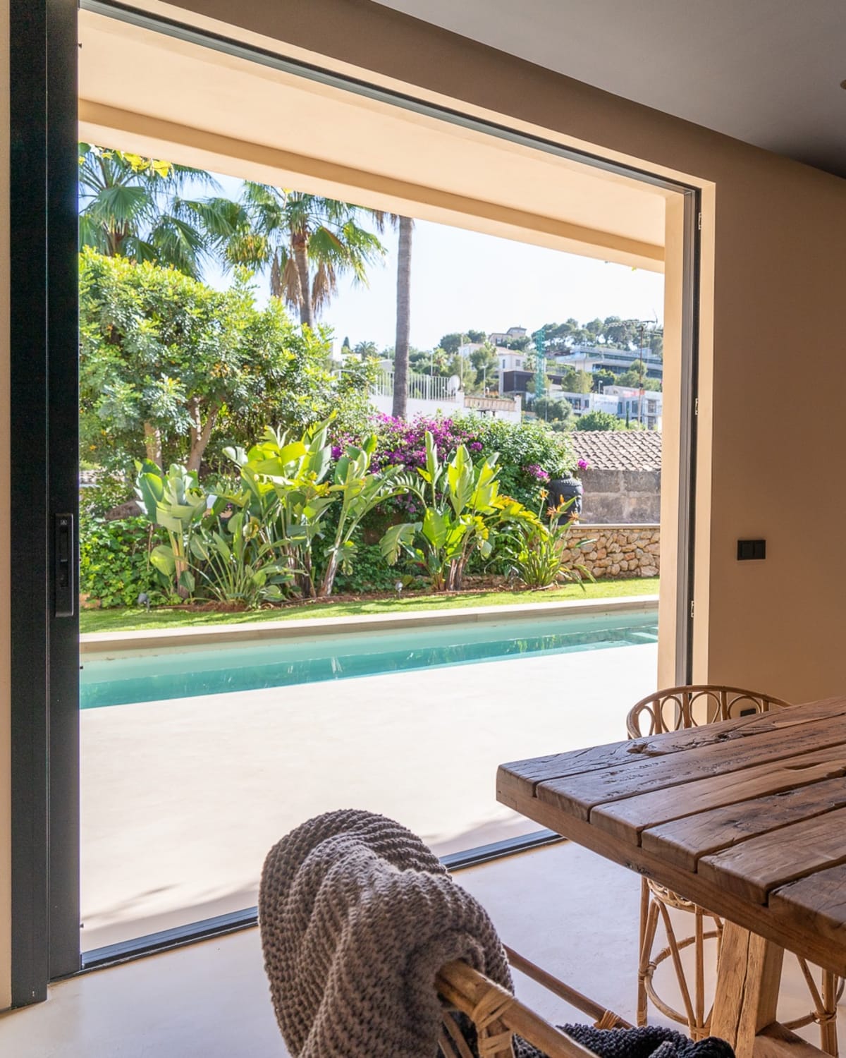 Dining table beside an opening onto the pool, Falco 10