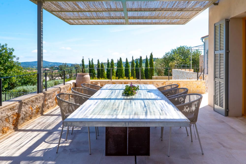 Der Esstisch auf der Terrasse, dahinter eine Zypressenreihe, Finca Sant Llorenç