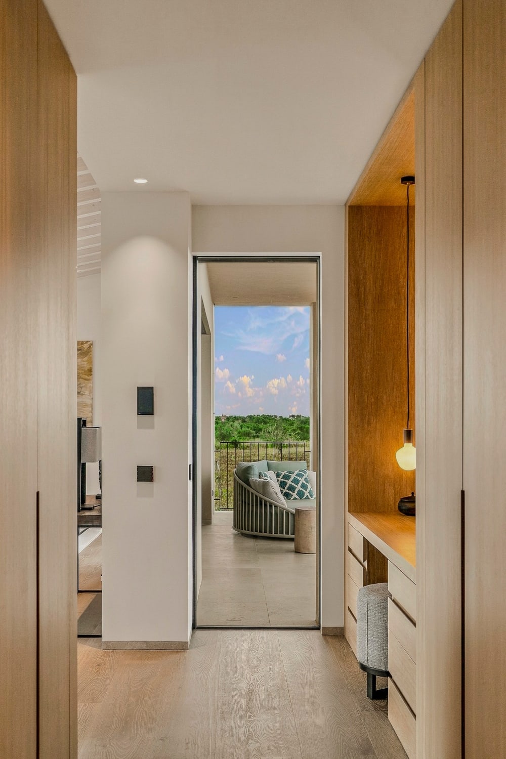 Ein Ankleidezimmer aus Eiche mit Blick durch eine verglaste Tür auf einen Balkon, Santanyí III
