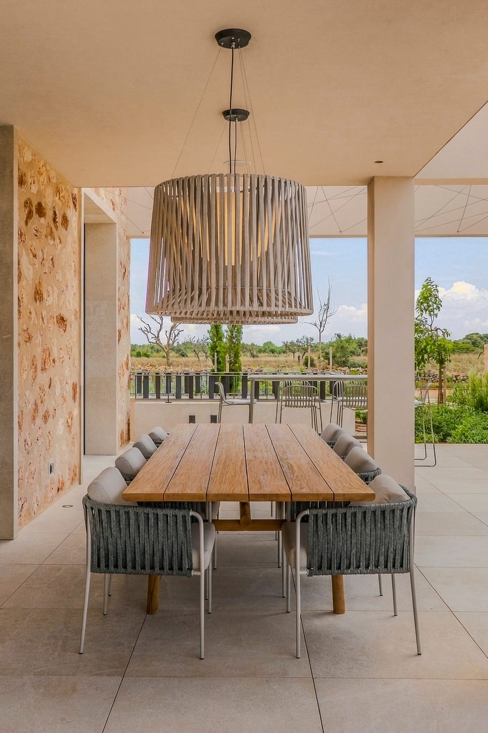 Der Esstisch im Freien unter einer überdachten Terrasse mit Blick über den Garten, Santanyí III