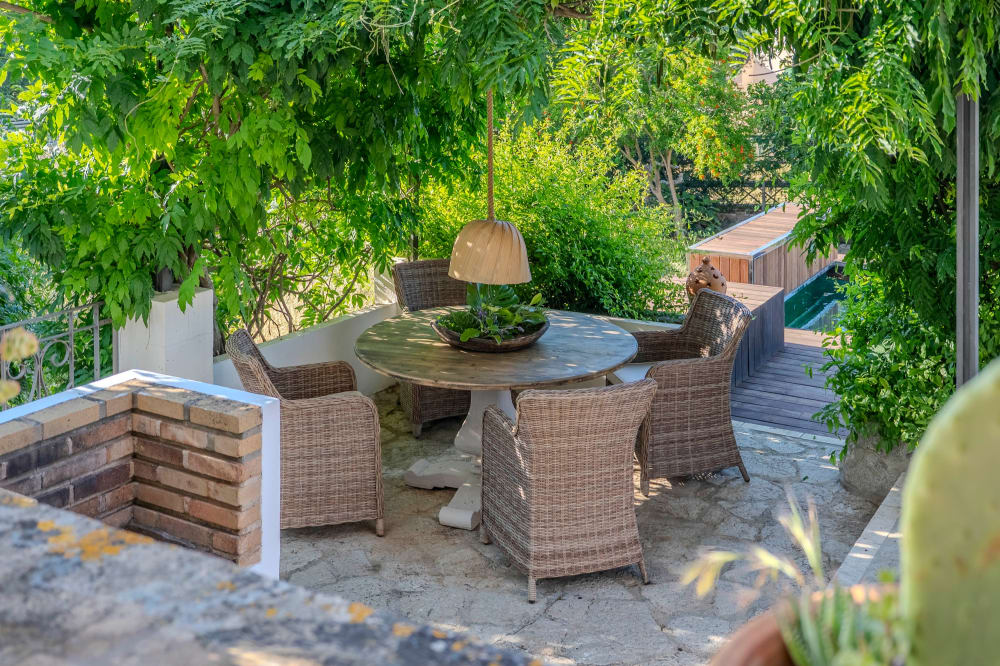 Der Tisch im Freien unter den Bäumen, neben dem Pool, Exklusive Gartenwohnung