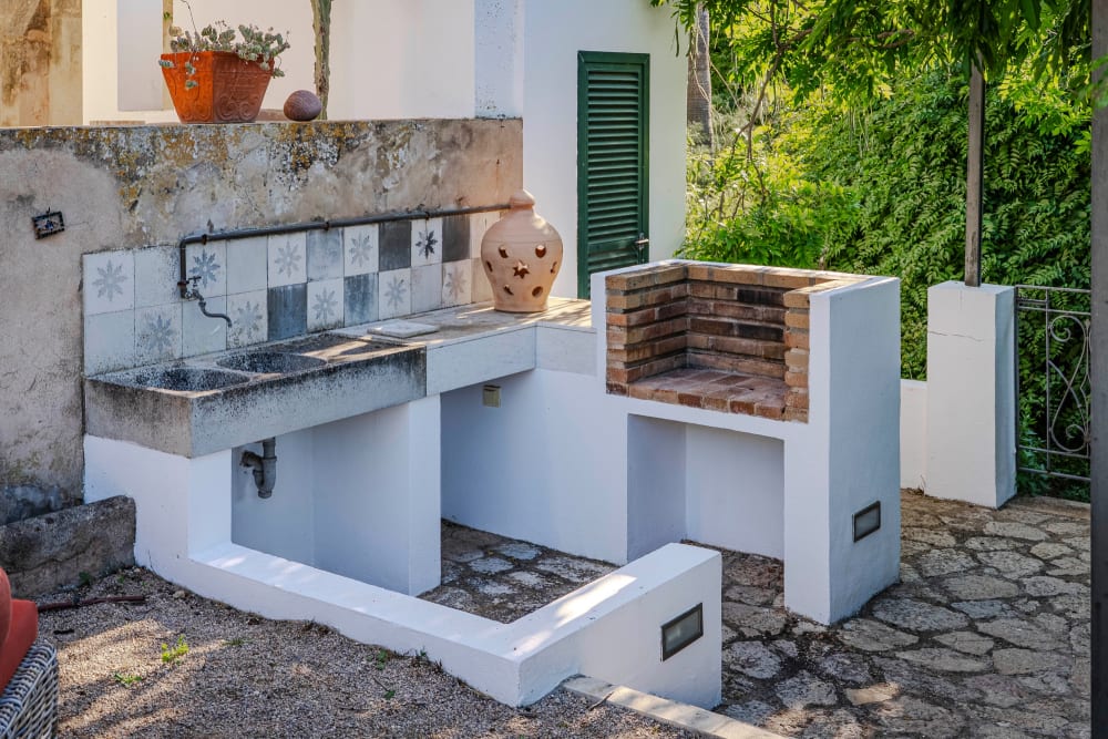 Der Grill und das geflieste Waschbecken im Freien, Exklusive Gartenwohnung