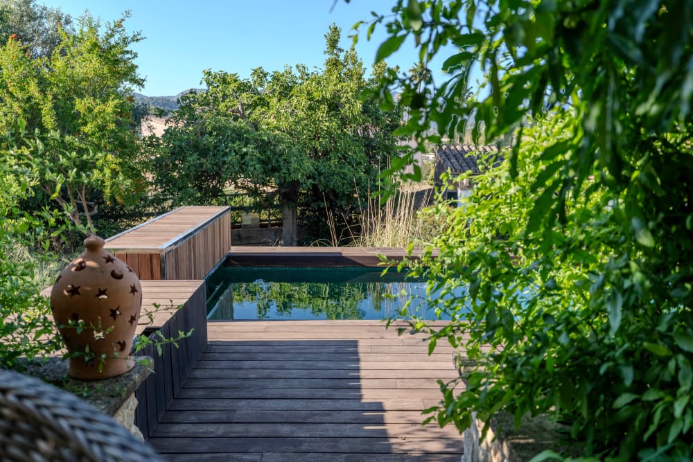 Die Holzterrasse, die zum Pool führt, Exklusive Gartenwohnung