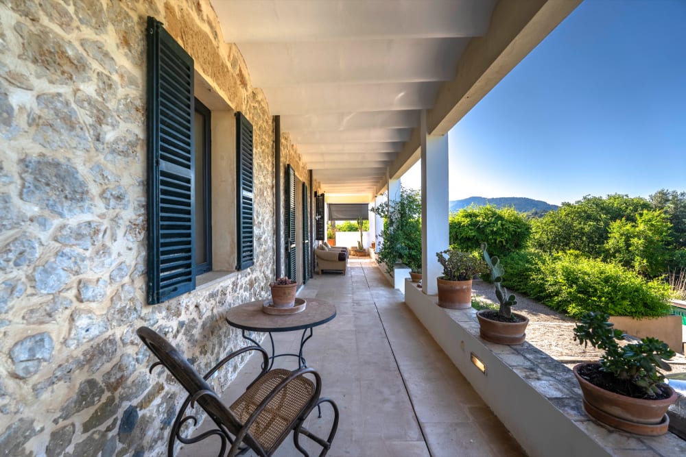Die überdachte Terrasse entlang der Steinmauer, Exklusive Gartenwohnung