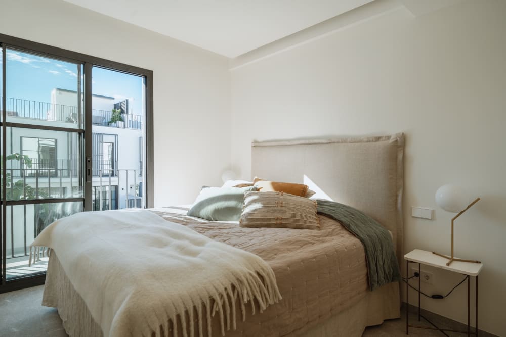 Ein Schlafzimmer, das Bett vor einer verglasten Tür, Reihenhaus in Portixol