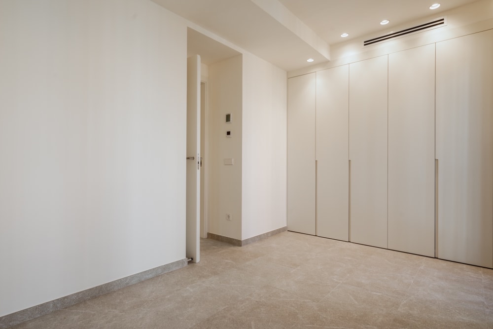 Ein Ankleidezimmer mit weißen Schränken, Reihenhaus in Portixol