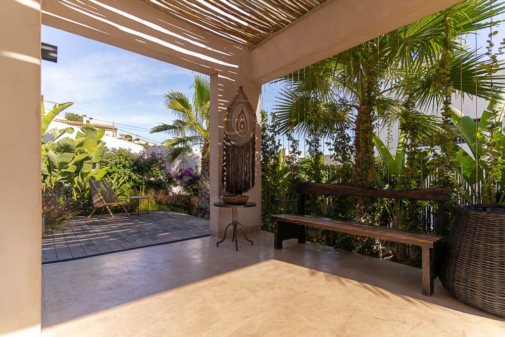 Covered terrace with a wooden bench, opening onto the garden, Falco 13