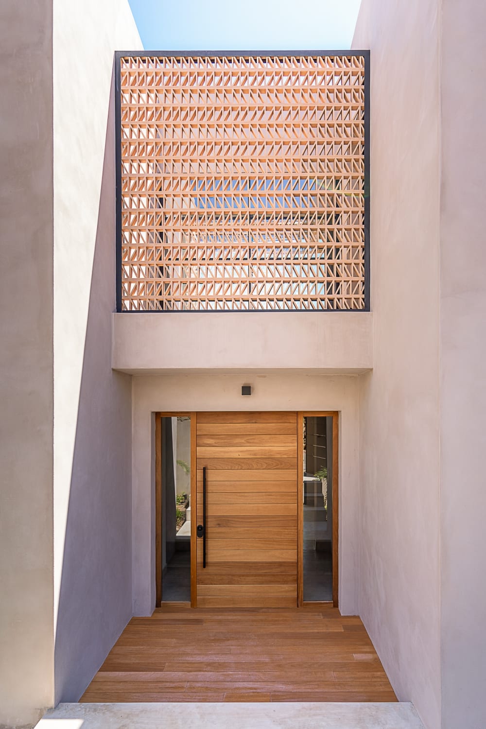 Wooden entrance door under a woven timber screen, Falco 13