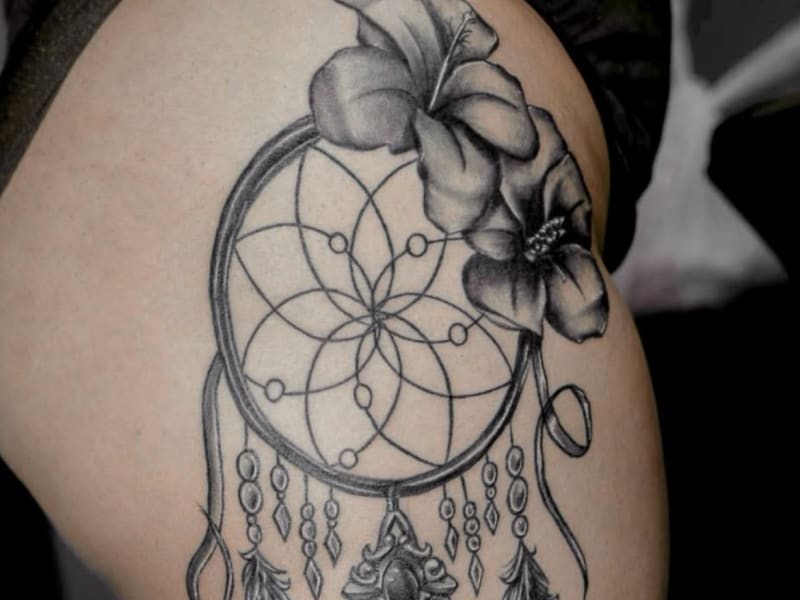Black and grey dreamcatcher with hibiscus flower tattoo featuring delicate fine line work and intricate detail by Jose at Sueño Tattoo in Laurel, MD