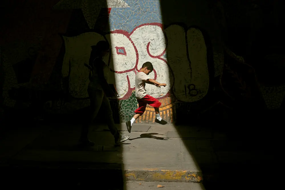 Niño brincando en haz de luz