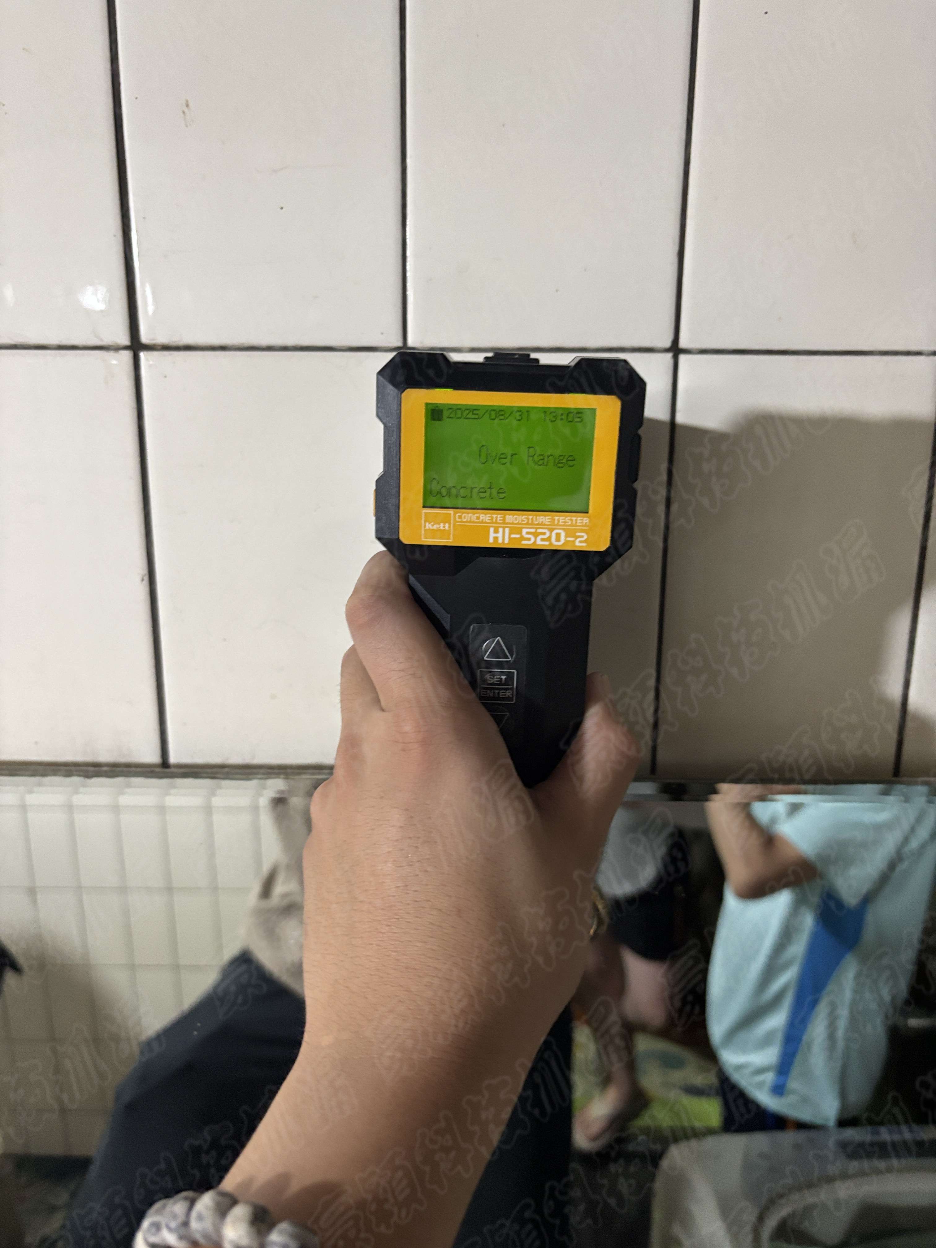 使用混凝土濕度計（型號HI-520-2）檢測牆面濕度的情景