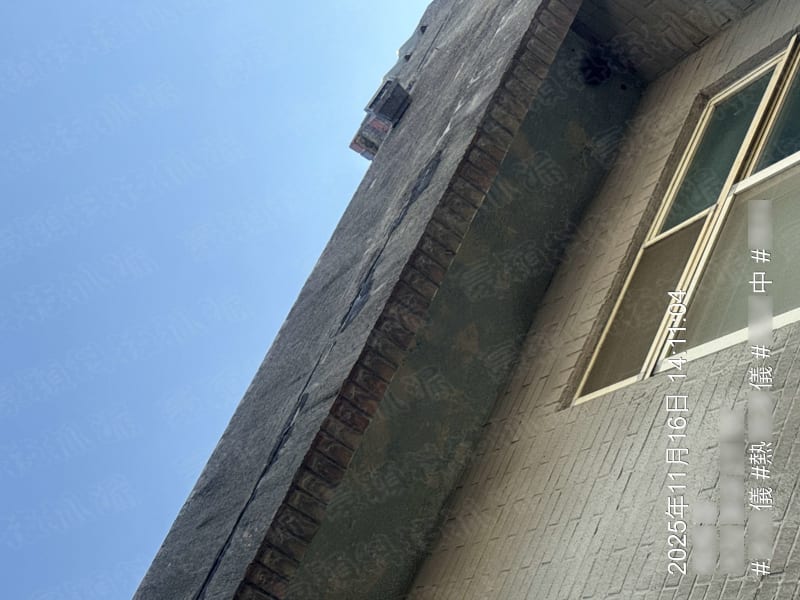 圖片展示了一棟建築物的外牆與屋頂交界處，牆面為灰色磚塊結構，屋頂部分可見黑色防水層。牆面有明顯的污漬和可能的水損跡象，屋頂邊緣有滲漏的痕跡。該圖片主要用於建築漏水檢測和防水工程的專業分析。
