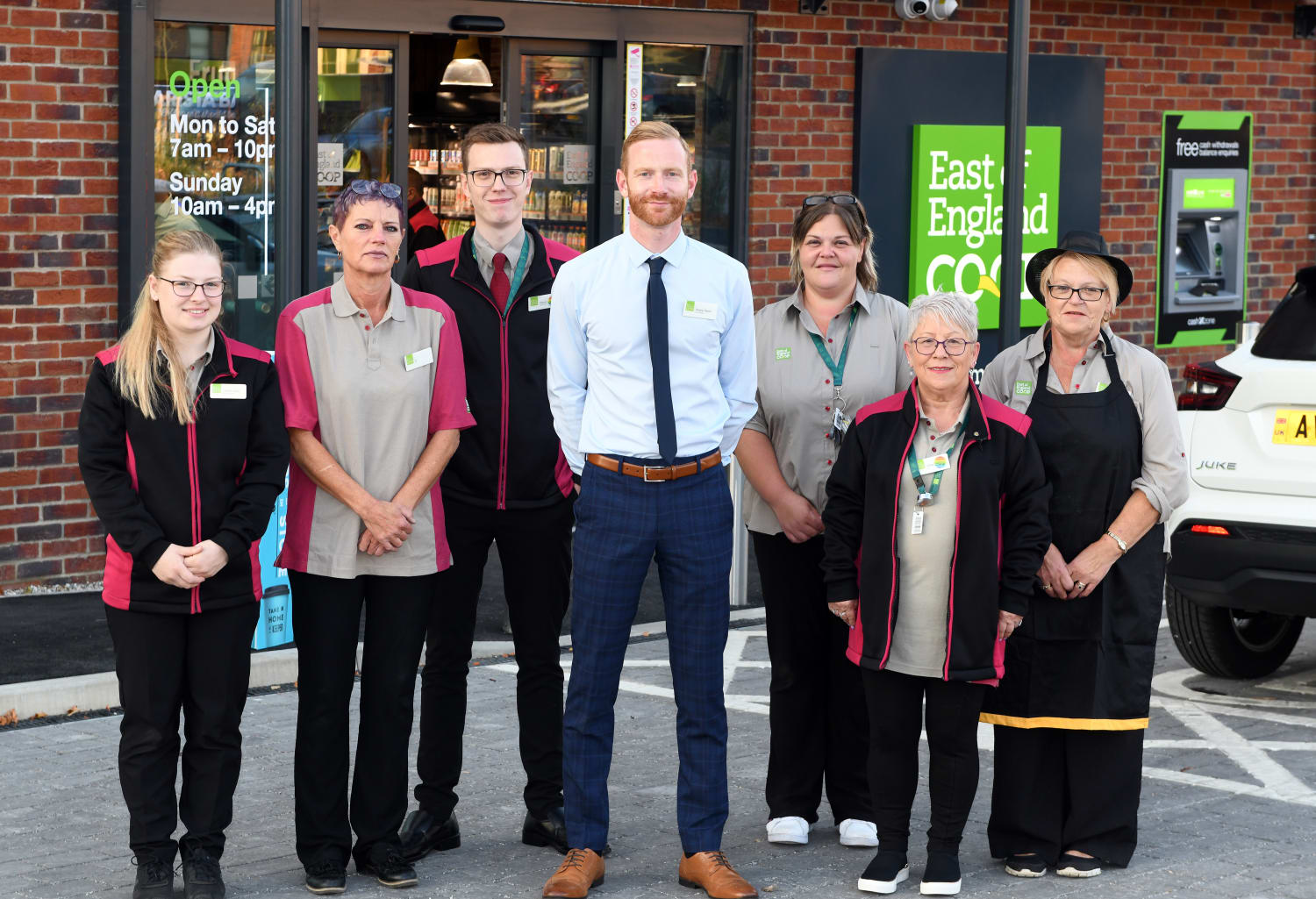 Needham Market food store manager and team, standing outside the new store entrance.