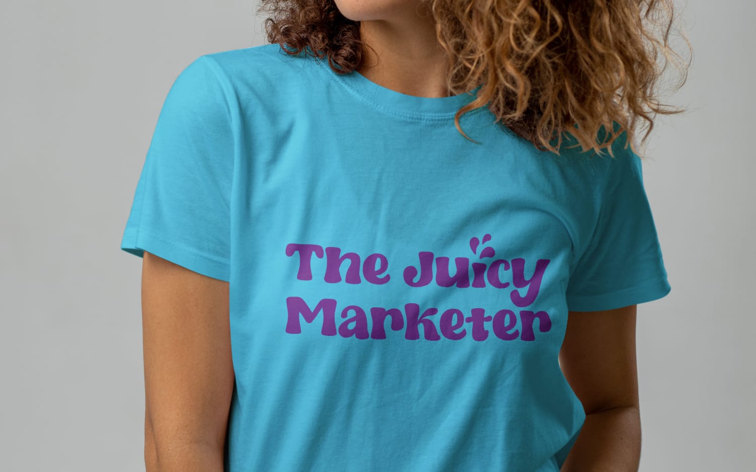 Woman wearing a light blue T-short with the words The Juicy Marketer on the front