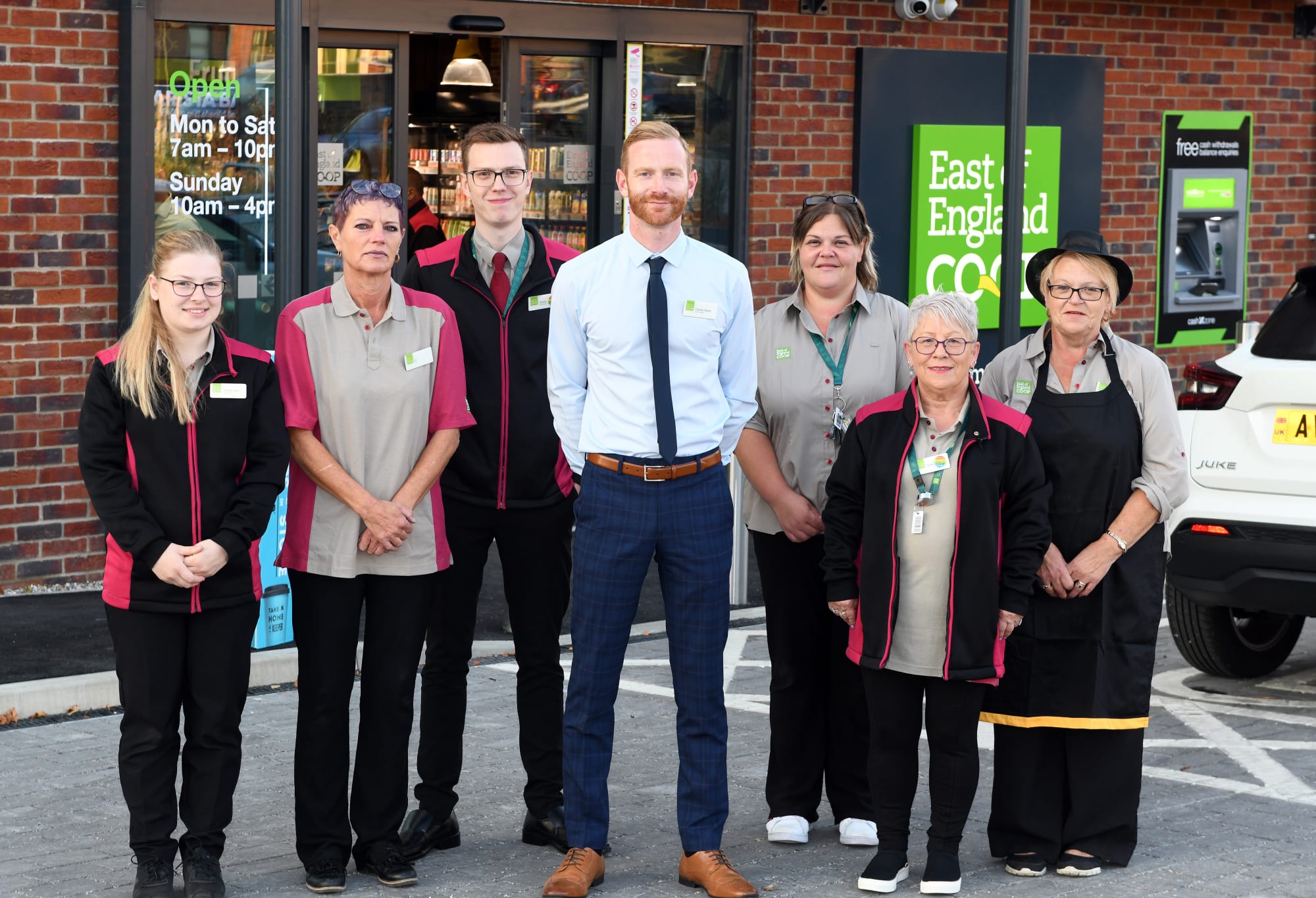 Needham Market food store manager and team, standing outside the new store entrance.
