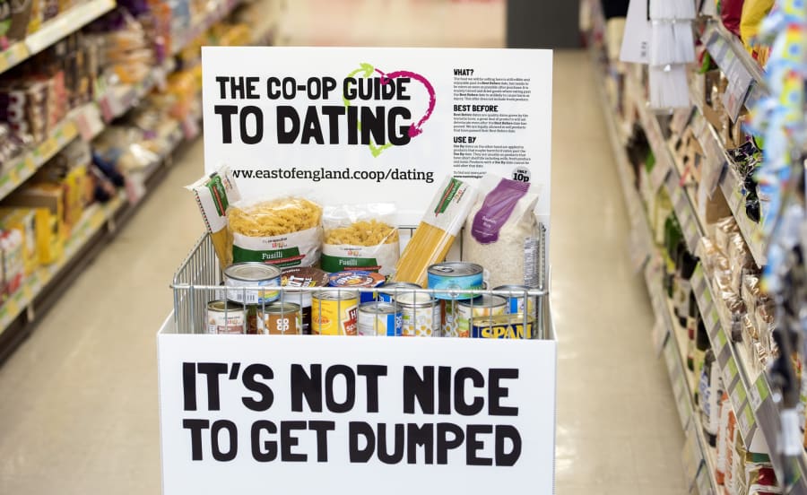 The campaign food cage is filled with packets and tins, standing in the middle of a food store aisle.
