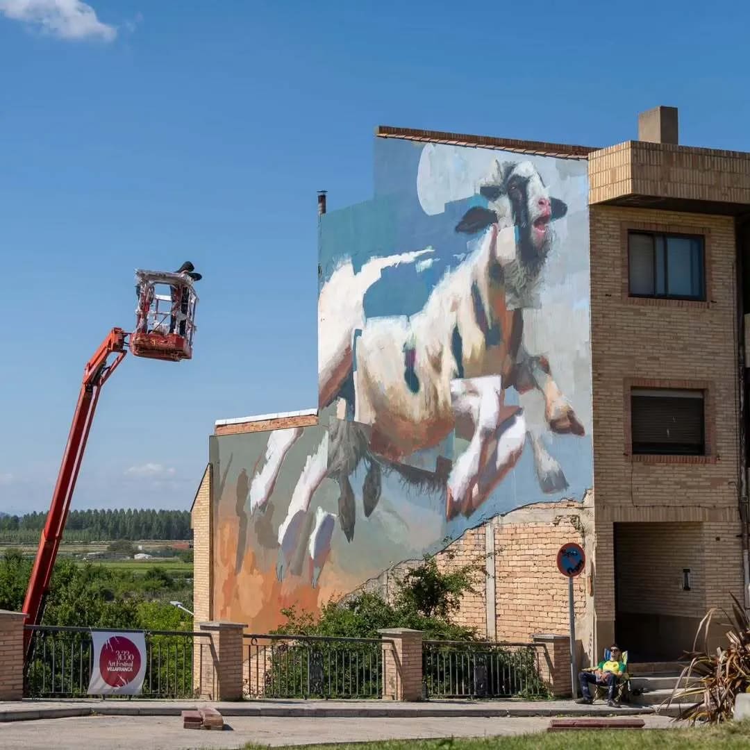 Mural de una cabra corriendo pintado en la pared de un edificio.