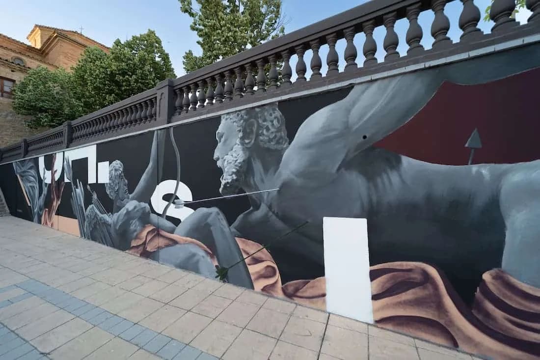 Mural con figuras humanas en un puente.