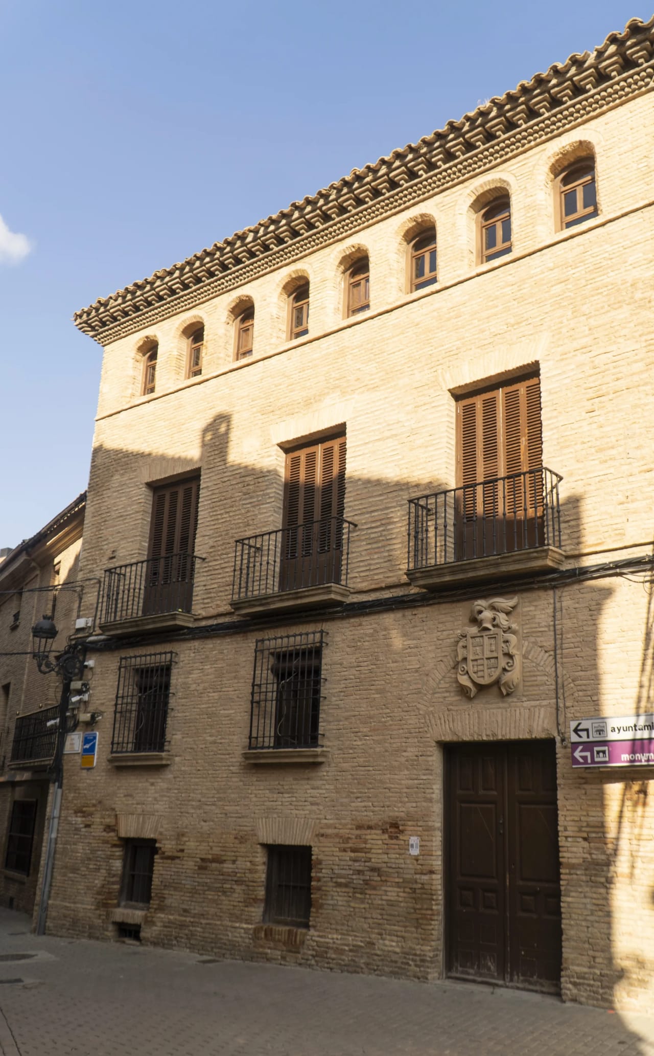 Edificio histórico de tres pisos con balcones y detalles arquitectónicos.
