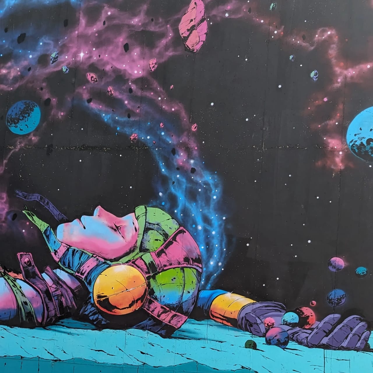 Astronauta colorido yacente en el espacio con nebulosas y planetas.