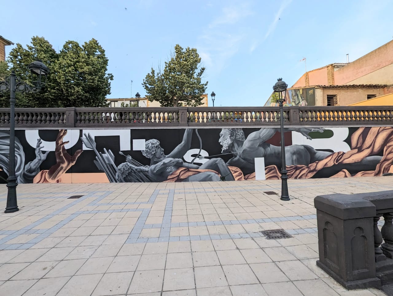 Mural con figuras mitológicas en una pared en blanco y negro.