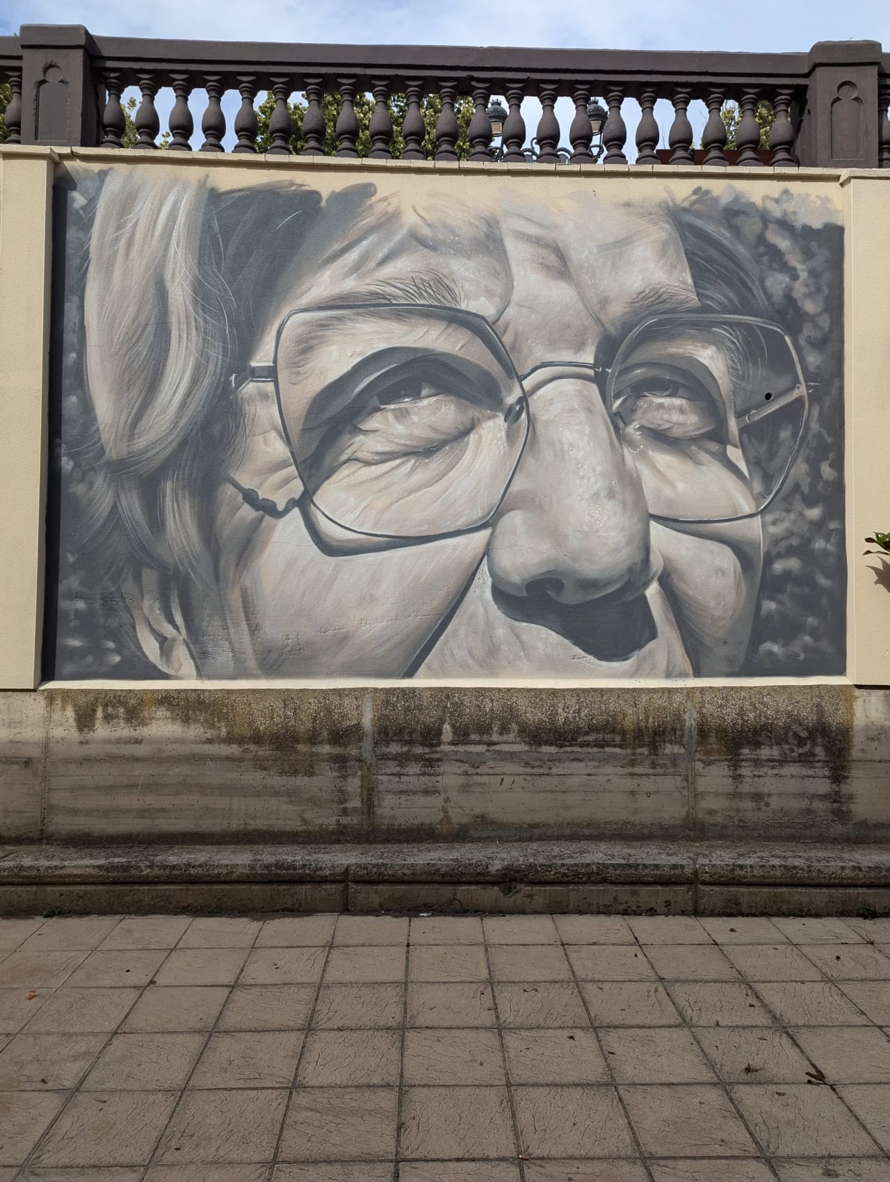 Mural de una mujer con gafas en una pared.
