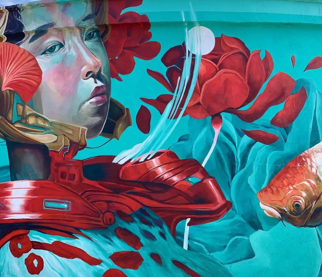 Mural de una mujer con un pez y flores rojas en un fondo turquesa.