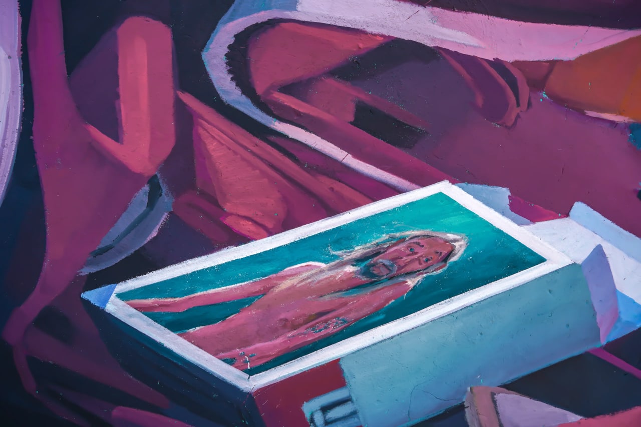 Mujer desnuda dentro de una caja de agua azul turquesa.