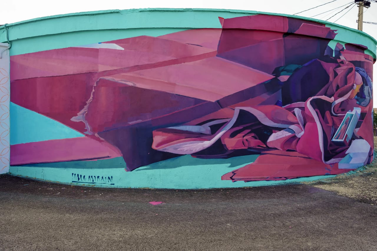 Mural abstracto en pared con colores rosa, azul y verde.