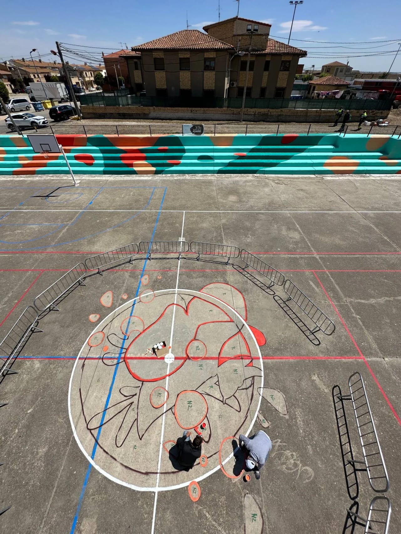 Pintura de una cancha de baloncesto con diseño de flor en el centro.