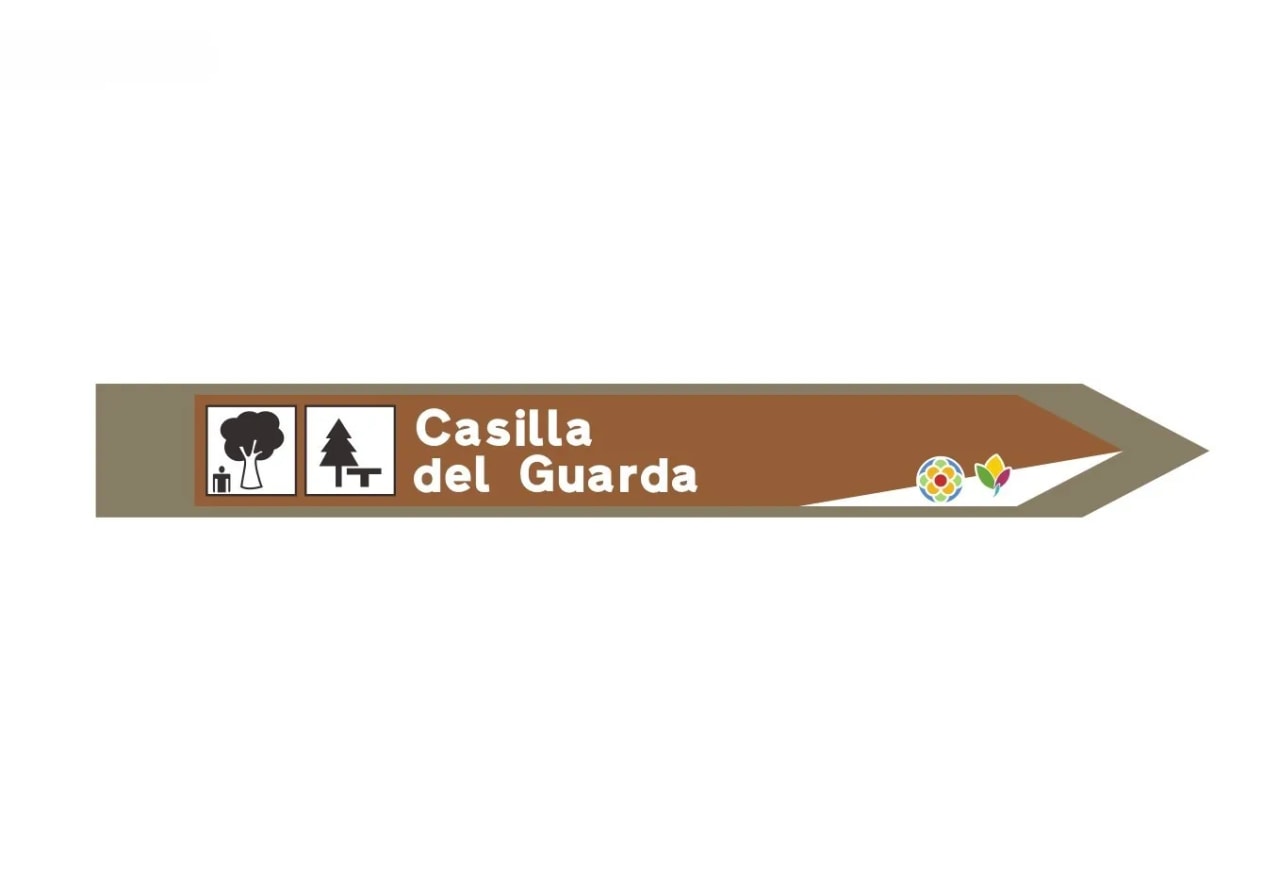 Señal direccional marrón con texto "Casilla del Guarda" y logotipos.