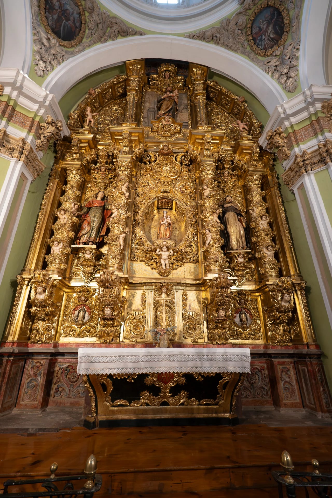 Retablo barroco con figuras doradas y ornamentos en una iglesia.