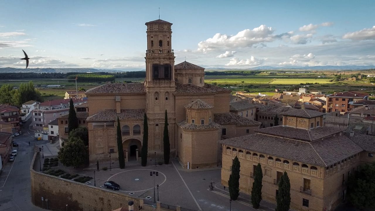Iglesia histórica con torre campanario en un pueblo rural.